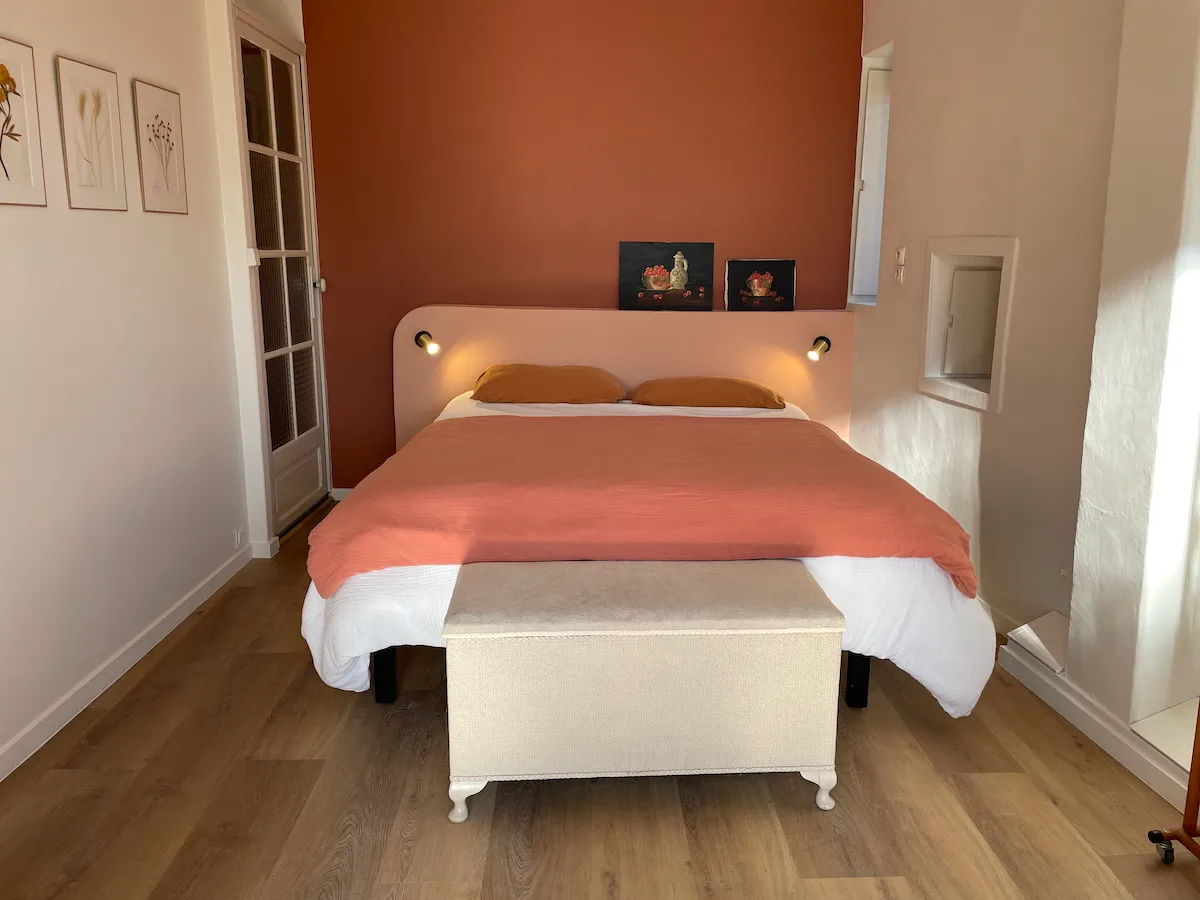 Chambre avec mur terre cuite et cadres botaniques