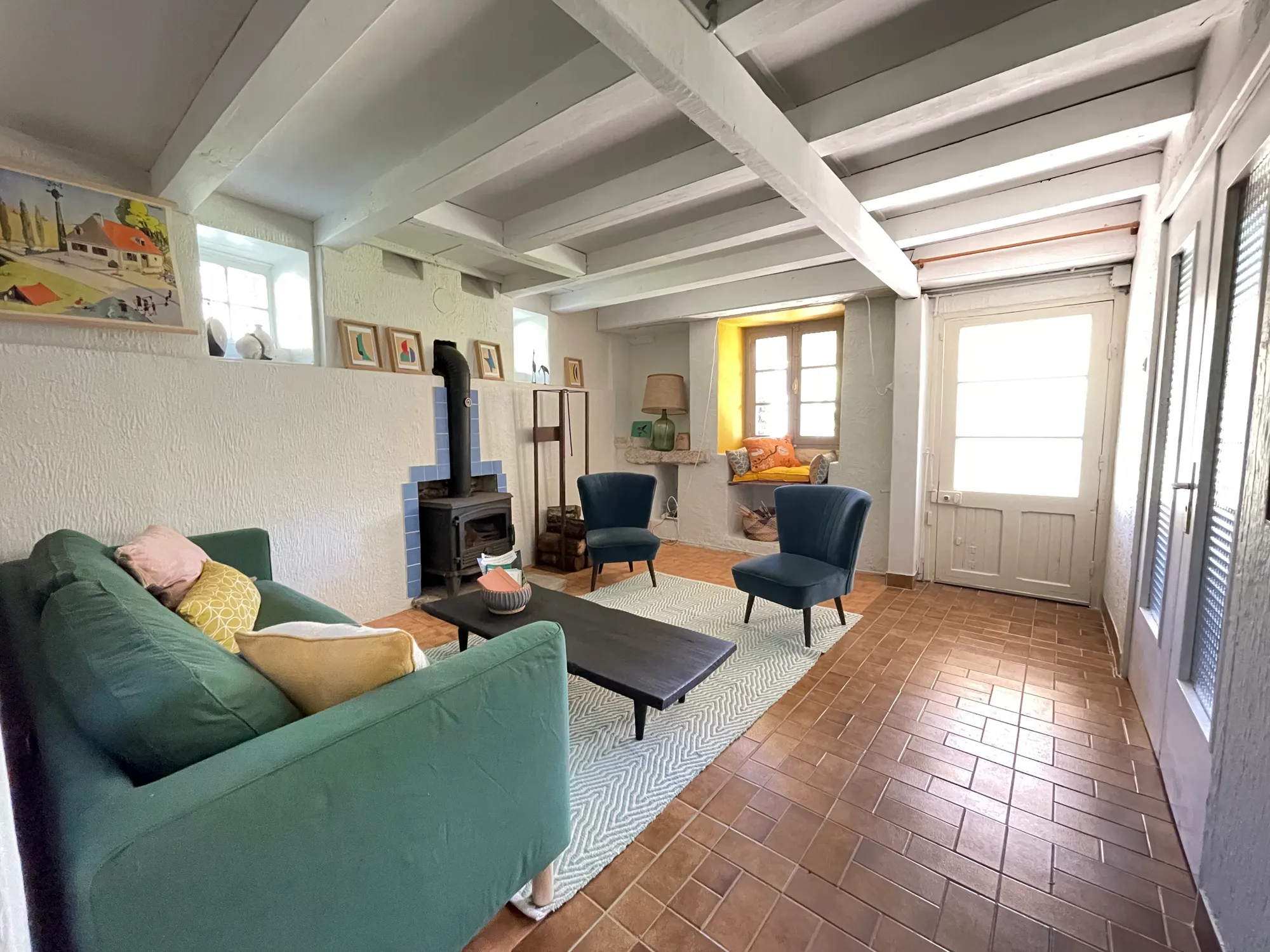 Salon avec poêle à bois et poutres